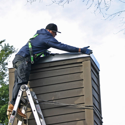 man installing a chimney chase covers